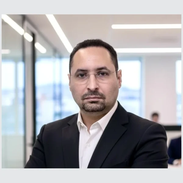 Yaz Bekkar, en veste sombre et chemise blanche, photographié dans des bureaux.